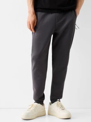 Zdjęcie produktu Bershka Spodnie Jogger Z Dzianiny Dresowej Z Widocznymi Szwami Mężczyzna Szary
