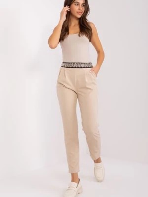 Zdjęcie produktu Beżowe spodnie z materiału z ozdobną gumką w pasie Italy Moda
