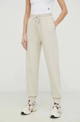Zdjęcie produktu Calvin Klein Jeans spodnie dresowe bawełniane kolor beżowy gładkie