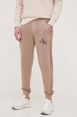 Zdjęcie produktu Calvin Klein Jeans spodnie dresowe bawełniane kolor brązowy gładkie