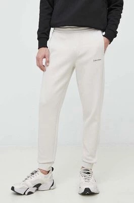 Zdjęcie produktu Calvin Klein spodnie dresowe męskie kolor beżowy gładkie