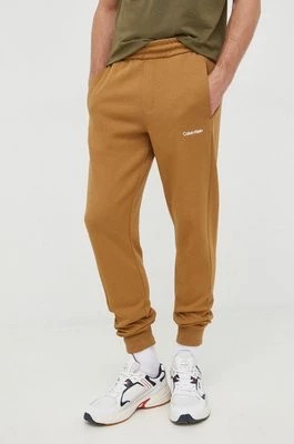 Zdjęcie produktu Calvin Klein spodnie dresowe męskie kolor brązowy gładkie