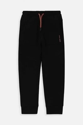 Zdjęcie produktu Coccodrillo spodnie dresowe bawełniane dziecięce kolor czarny gładkie