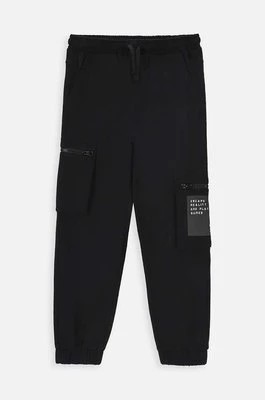 Zdjęcie produktu Coccodrillo spodnie dresowe dziecięce kolor czarny z nadrukiem