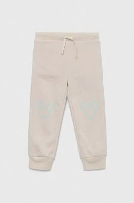 Zdjęcie produktu GAP spodnie dresowe dziecięce x Disney kolor beżowy z nadrukiem