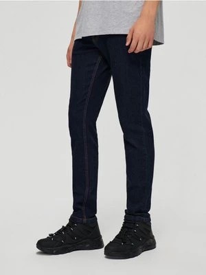 Zdjęcie produktu Granatowe jeansy slim fit z kontrastową nicią House