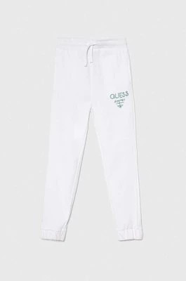 Zdjęcie produktu Guess spodnie dresowe bawełniane dziecięce kolor biały z nadrukiem
