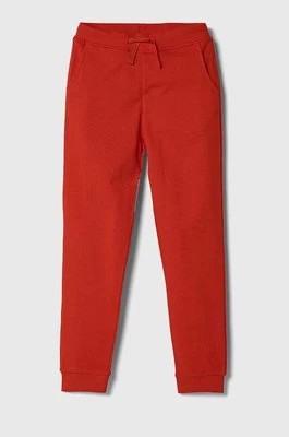 Zdjęcie produktu Guess spodnie dresowe bawełniane dziecięce kolor czerwony gładkie