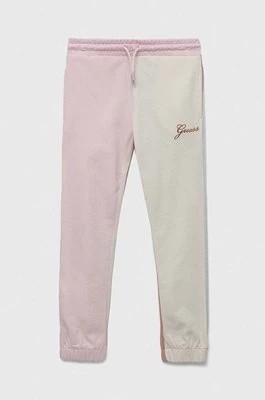 Zdjęcie produktu Guess spodnie dresowe bawełniane dziecięce kolor różowy wzorzyste
