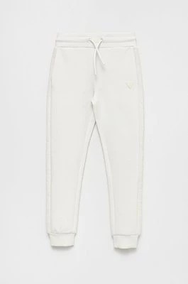 Zdjęcie produktu Guess spodnie dresowe dziecięce kolor biały gładkie