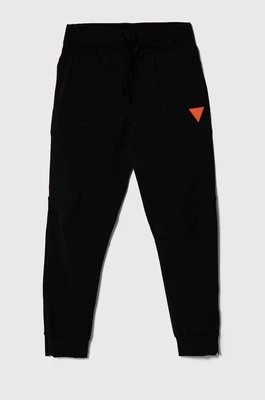 Zdjęcie produktu Guess spodnie dresowe dziecięce kolor czarny gładkie