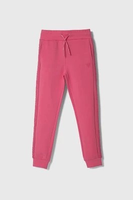 Zdjęcie produktu Guess spodnie dresowe dziecięce kolor różowy gładkie