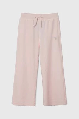 Zdjęcie produktu Guess spodnie dresowe welurowe dziecięce kolor różowy gładkie