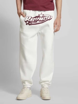 Zdjęcie produktu Spodnie dresowe o kroju regular fit z nadrukiem z logo REVIEW