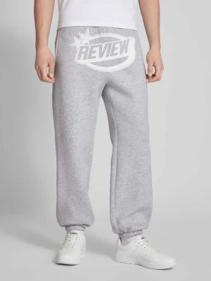 Zdjęcie produktu Spodnie dresowe o kroju regular fit z nadrukiem z logo REVIEW