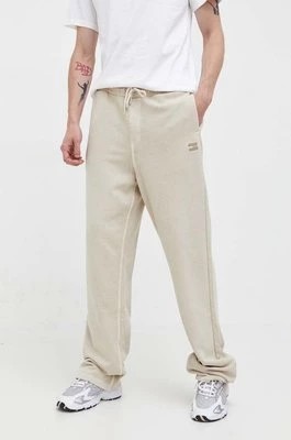 Zdjęcie produktu Tommy Jeans spodnie dresowe bawełniane kolor beżowy gładkie