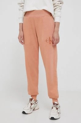 Zdjęcie produktu Calvin Klein Jeans spodnie dresowe bawełniane kolor pomarańczowy gładkie