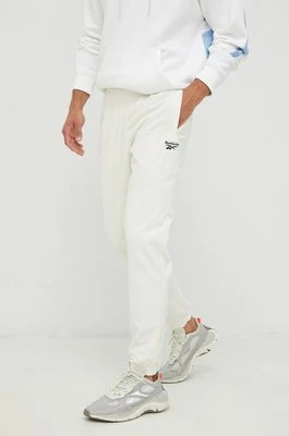 Zdjęcie produktu Reebok Classic spodnie dresowe męskie kolor beżowy z nadrukiem